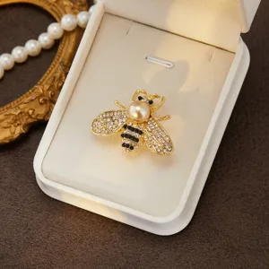 Close-up detail of exquisite bee brooch featuring shiny rhinestones, pearl head and gold tone.