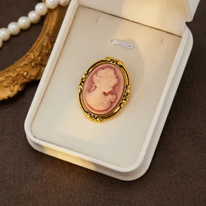 Vintage cameo brooch detail shot, elegant gold-toned frame with retro portrait relief for women.