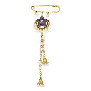 Vintage gold safety pin brooch detail, ethnic purple stone white pearl tassel pendant close up.