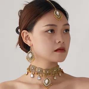 Détail en gros plan d'un ensemble de bijoux collier ras de cou, boucles d'oreilles et bijoux de tête.