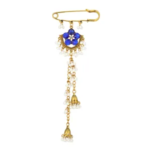 Detail view of ethnic style safety pin brooch with blue crystals and long pearl tassels.