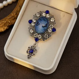 Exquisite vintage medieval cameo brooch featuring blue rhinestones and filigree design detail.