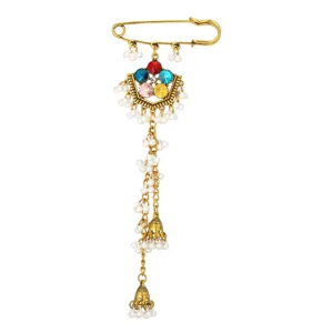 Detailed view of an ethnic rhinestone pearl tassel safety pin brooch with vintage gold finish.