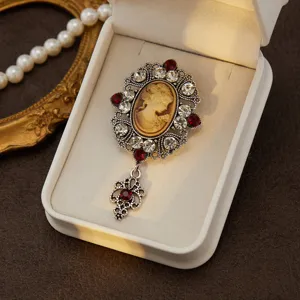 Vintage cameo brooch detail, medieval court style crystal rhinestone alloy jewelry close up.