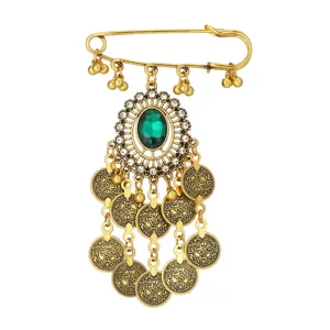 Broche dorada vintage estilo bohemio con piedra verde y colgantes de monedas con flecos.