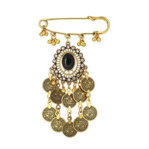 Broche de imperdible dorado vintage étnico bohemio con piedra negra y borlas de monedas colgantes.