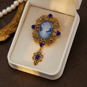 Close-up detail of vintage medieval cameo brooch, ornate gold filigree and sparkling rhinestones.