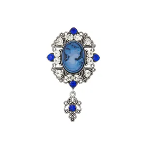 Vintage medieval cameo brooch detail shot, ornate silver filigree frame with rhinestones.