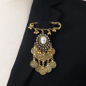 Detalle de broche borla moneda vintage oro, colgante ovalado pedrería accesorio pin.