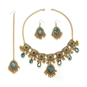 Détail de parure de bijoux vintage exotique montrant collier, boucles et tikka dorés.