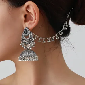 Gros plan detaille de boucles d'oreilles bohemes vintage avec chaine de cheveux et cristaux.