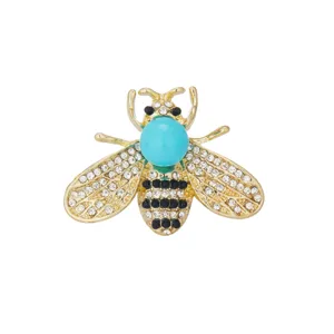 Exquisite bee brooch detail featuring sparkling rhinestones, turquoise bead, and elegant design.