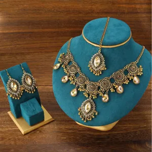 Gros plan détaillé de la parure de bijoux bohème vintage avec finition or antique et strass.