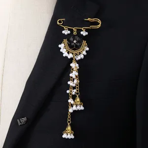 Elegant ethnic gold safety pin brooch featuring black crystals, white pearls and long tassels.