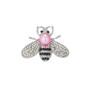 Detailed close-up of a sparkling rhinestone bee brooch with a pink pearl head and silver finish.