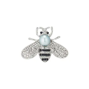 Detailed shot of exquisite crystal rhinestone bee brooch with faux pearl head for stylish wear.