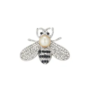 Close-up detail of silver crystal bee brooch with pearl center and sparkling rhinestones.
