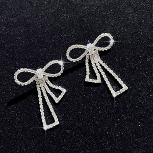 Nahaufnahme funkelnder Strass-Schleife-Fransen-Ohrringe, exquisite Handwerkskunst und Luxus-Stil.