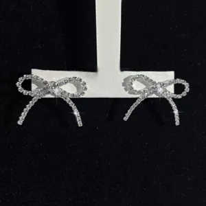 Nahaufnahme von funkelnden Strass Schleifen Quasten Ohrringen, elegantes Schmuckdetail.