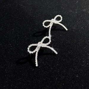 Nahaufnahme Detail von Luxus Strass Schleife Quaste Ohrringen, glänzender Schmuck.