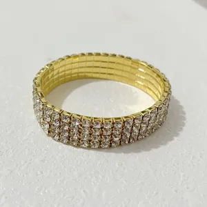 Goldfarbenes elastisches Armband mit mehreren Reihen glänzender Strasssteine für Damen.