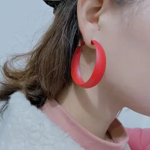Matte red hoop earrings detail close-up showing smooth finish and stylish geometric design.