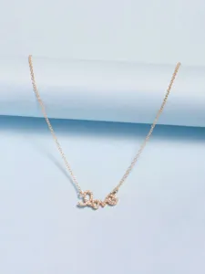 Primer plano del colgante Love dorado con detalles de pedrería brillante, estilo elegante.