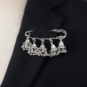 Detailed close-up of a vintage silver jhumka bell brooch charm attached to a black fabric.