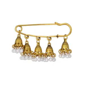 Close-up view of vintage gold safety pin with ethnic bell charms and white pearl tassels.