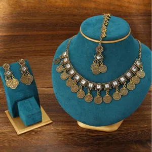 Bohemian vintage ethnic gold jewelry set with necklace earrings and maang tikka detailing.