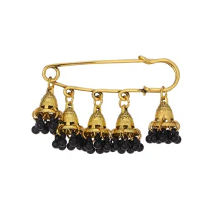 Close up view of vintage gold safety pin brooch with hanging ethnic bell charms and black beads.