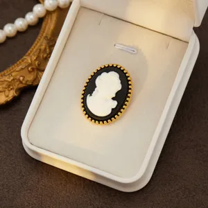 Vintage court style cameo brooch, elegant black and white portrait design with gold beaded rim.