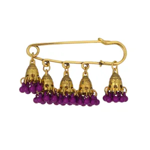 Close-up view of vintage bohemian brooch featuring dangling bell charms and purple beads.