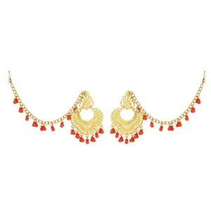 Detailed close-up view of ethnic gold carved ear chain earrings adorned with red beads.