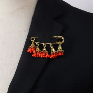 Vintage gold-tone safety pin brooch with red bead tassels and ethnic bell charms for women.