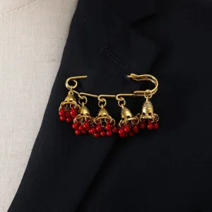 Vintage bell tassel brooch pin with red beads, exquisite retro court style jewelry detail shot.