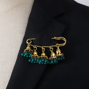 Close-up details of retro court style bell tassel brooch with green beads pinned on suit lapel.