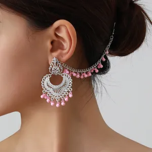 Detailed shot of ethnic vintage style silver ear chain with pink beads, exquisite design.