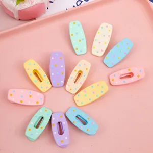 Detailed view of colorful macaron hair clips with cute polka dot design for styling bangs securely.