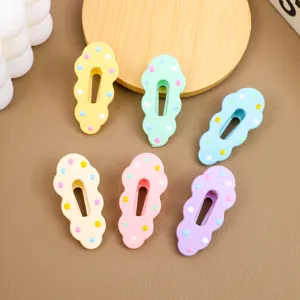 Detailed close-up of pastel cloud-shaped hair clips featuring colorful polka dot designs.