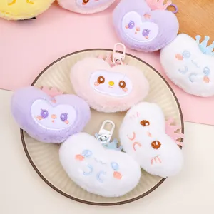 Close-up of cute plush heart and cloud keychains with embroidered faces and mini crowns.