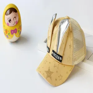 Nahaufnahme der gelben Kinder Mesh Baseballkappe mit silbernen Hasenohren und goldenen Sternen.