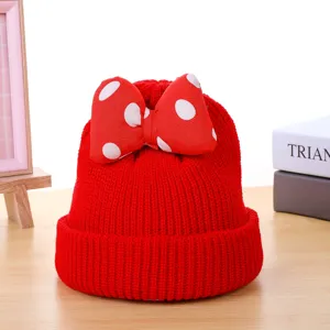 Kids red knit beanie hat with polka dot bow detail, warm winter baby headwear accessory.