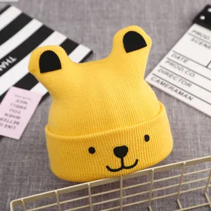 Cute yellow baby knit hat with bear ears and embroidered face for autumn and winter warmth.
