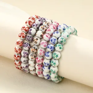 Close-up detail of colorful ceramic beaded bracelets with delicate floral patterns for DIY jewelry.