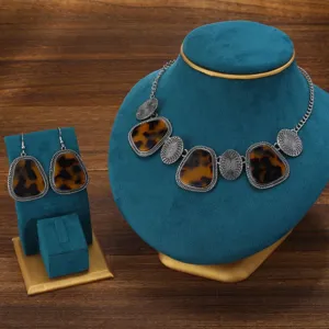 Vintage geometric necklace and earrings set detail showcasing tortoiseshell pattern and silver metal.
