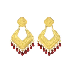 Elegant retro gold-tone drop earrings featuring intricate filigree patterns and red beads.