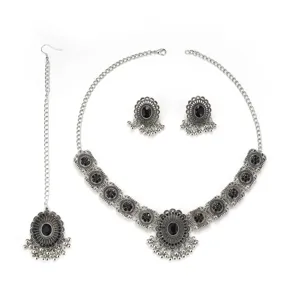 Detailed view of vintage ethnic silver jewelry set with black stones and drop tassels.