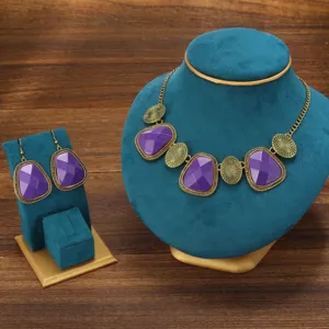 Vintage purple stone necklace and earrings detail view showcasing intricate gold metal filigree design.