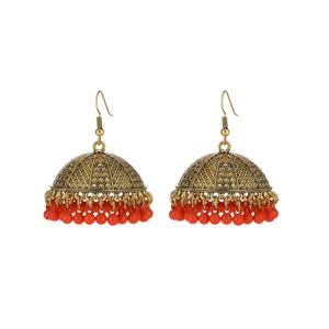 Close-up view of the intricate vintage gold dome texture and vibrant red hanging bead tassels.